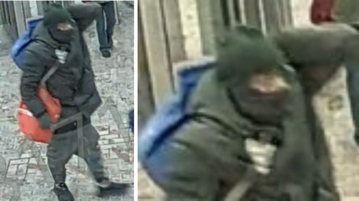 Toronto police surveillance image of suspect in dark hooded jacket and face covering carrying red or orange bag and backpack in Kennedy Station attempted fire incident investigation
